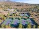 Aerial view of tennis courts surrounded by lush greenery within a vibrant community at 1556 Olivia Pkwy, Henderson, NV 89011