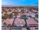 A beautiful aerial view shows a home with city and mountain views, and a tile roof, surrounded by palm trees at 1613 Shadow Rock Dr, Las Vegas, NV 89117