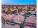 An aerial view of a suburban neighborhood showcases a tile roof home with lush landscaping and a backyard pool at 1613 Shadow Rock Dr, Las Vegas, NV 89117