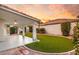 Beautiful backyard with lush green artificial turf, covered patio, and desert landscaping creates a tranquil outdoor space at 1613 Shadow Rock Dr, Las Vegas, NV 89117