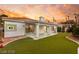 A relaxing backyard with lush green artificial turf, desert landscaping and a covered patio at 1613 Shadow Rock Dr, Las Vegas, NV 89117