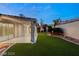 A backyard with artificial grass and a covered patio area for outdoor relaxation and entertainment at 1613 Shadow Rock Dr, Las Vegas, NV 89117
