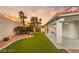 Beautiful backyard with lush artificial turf, desert landscaping and covered patio at 1613 Shadow Rock Dr, Las Vegas, NV 89117