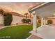 A serene backyard featuring artificial turf, desert landscaping and covered patio at 1613 Shadow Rock Dr, Las Vegas, NV 89117