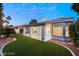 Exterior view of a house with manicured lawn, covered patio, and desert landscaping, offers a serene outdoor living space at 1613 Shadow Rock Dr, Las Vegas, NV 89117