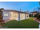 This home with an expansive artificial lawn, covered patio, and mature landscaping, creates a beautiful outdoor living space at 1613 Shadow Rock Dr, Las Vegas, NV 89117