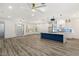 Well-lit living space features modern wood flooring, a kitchen island, and contemporary light fixtures at 1613 Shadow Rock Dr, Las Vegas, NV 89117