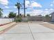 A concrete backyard space framed by trees under a blue sky at 1700 E Oakey Blvd, Las Vegas, NV 89104