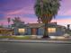Inviting single-story home with a tidy front yard, red door, and a mature palm tree at 1700 E Oakey Blvd, Las Vegas, NV 89104