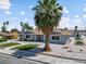 Inviting single-story home features a lush green lawn, desert landscaping, and a vibrant red front door at 1700 E Oakey Blvd, Las Vegas, NV 89104