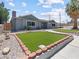 Charming single-story home featuring a well-maintained lawn, neutral stucco, and lush landscaping at 1700 E Oakey Blvd, Las Vegas, NV 89104