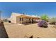 Wide backyard featuring a covered patio, desert landscaping, and plenty of open space at 1902 Panther Pl, North Las Vegas, NV 89031