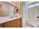 Well-lit bathroom boasts a shower-tub combo with updated fixtures and a spacious wood vanity for storage at 1902 Panther Pl, North Las Vegas, NV 89031