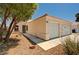 View of the home's exterior with xeriscaping, large shade tree and two car garage at 1902 Panther Pl, North Las Vegas, NV 89031
