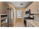 Bright kitchen with stainless steel refrigerator, white cabinets, and gas range oven at 1902 Panther Pl, North Las Vegas, NV 89031