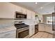 Modern kitchen with white cabinetry, stainless steel appliances, and a bright breakfast bar at 1902 Panther Pl, North Las Vegas, NV 89031