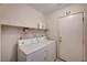 Functional laundry room equipped with a washer, dryer, and storage shelves at 1902 Panther Pl, North Las Vegas, NV 89031