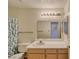 Well-lit bathroom with a tub and shower, a mirror, a sink, and a vanity with wooden cabinets and drawers at 2040 Mesquite Ln # 203, Laughlin, NV 89029