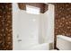 Bathroom showcases a bright, clean bathtub and shower with decorative wallpaper accents at 2050 W Warm Springs Rd # 4322, Henderson, NV 89014