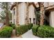 Beautiful view of a stucco two-story building with desert landscaping and manicured shrubs and trees at 2050 W Warm Springs Rd # 4322, Henderson, NV 89014