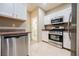 Bright kitchen featuring white cabinets and stainless steel appliances, including dishwasher and oven at 2050 W Warm Springs Rd # 4322, Henderson, NV 89014