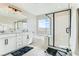 Bright bathroom featuring double vanity, soaking tub, and glass-enclosed shower at 2417 Fasano St, Henderson, NV 89044