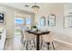 Bright dining area with modern chandelier, sliding glass doors to outdoor patio, and neutral decor at 2417 Fasano St, Henderson, NV 89044