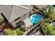 Aerial view of backyard featuring a sparkling pool, spa, covered patio, and artificial turf at 2440 Ping Dr, Henderson, NV 89074