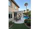 Lush backyard with covered patio, outdoor dining area, and sparkling pool provides the perfect space for outdoor living at 2440 Ping Dr, Henderson, NV 89074