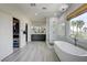 Luxurious bathroom with a stand-alone tub, glass shower, and a double vanity with gray cabinetry and a closet at 2440 Ping Dr, Henderson, NV 89074