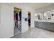 Well-organized Primary bath with a double vanity, walk-in closet, and sleek gray cabinetry for ample storage at 2440 Ping Dr, Henderson, NV 89074