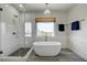 Serene bathroom featuring a freestanding tub, a glass-enclosed shower, and stylish fixtures with a window view at 2440 Ping Dr, Henderson, NV 89074