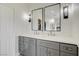 Bathroom vanity featuring gray cabinets, double sinks, quartz counters, modern fixtures, and stylish lighting at 2440 Ping Dr, Henderson, NV 89074