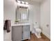 A well-lit half-bathroom features a gray vanity, a mirror, and wood-look floors at 2440 Ping Dr, Henderson, NV 89074