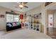 Spacious bedroom with a couch, desk, cube shelving, and hardwood flooring visible into the hallway at 2440 Ping Dr, Henderson, NV 89074