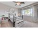 Charming bedroom with a black metal bed frame, white storage bench, and a bright window view at 2440 Ping Dr, Henderson, NV 89074
