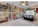 Cozy bedroom featuring extensive built-in bookshelves, ceiling fan, and a comfortable seating area by the bright window at 2440 Ping Dr, Henderson, NV 89074