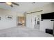 Spacious bedroom with a ceiling fan, plush carpeting, and a barn door leading to the ensuite bathroom at 2440 Ping Dr, Henderson, NV 89074