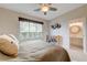 Comfortable bedroom boasts a large window, a bookshelf, and easy access to a bright, well-appointed ensuite bathroom at 2440 Ping Dr, Henderson, NV 89074