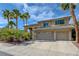 Charming two-story home showcasing a tile roof, three-car garage, and beautiful palm tree landscaping at 2440 Ping Dr, Henderson, NV 89074