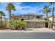 Beautiful two-story home with a tile roof, three car garage, and lush desert landscaping at 2440 Ping Dr, Henderson, NV 89074