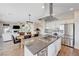 Open kitchen featuring stainless steel appliances, an island cooktop, and seamless connection to the living and dining areas at 2440 Ping Dr, Henderson, NV 89074