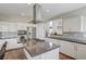 Well-lit kitchen featuring stainless steel appliances, an island cooktop, and white cabinets at 2440 Ping Dr, Henderson, NV 89074