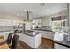 Modern kitchen featuring an island cooktop, granite countertops, stainless steel appliances, and tile backsplash at 2440 Ping Dr, Henderson, NV 89074