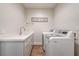 Bright laundry room featuring side-by-side washer and dryer and a utility sink at 2440 Ping Dr, Henderson, NV 89074