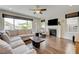 Bright living room featuring hardwood floors, a fireplace, and large windows at 2440 Ping Dr, Henderson, NV 89074