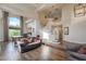 Elegant living room featuring a curved staircase, hardwood floors, and soaring ceilings with a large window at 2440 Ping Dr, Henderson, NV 89074