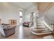 Open-concept living area showcasing hardwood floors, a staircase, and abundant natural light at 2440 Ping Dr, Henderson, NV 89074