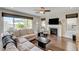 Bright living room featuring hardwood floors, a fireplace, and large windows at 2440 Ping Dr, Henderson, NV 89074