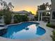 Backyard oasis featuring a pristine pool, covered patio, well-manicured landscaping, and privacy for relaxation and entertainment at 2440 Ping Dr, Henderson, NV 89074